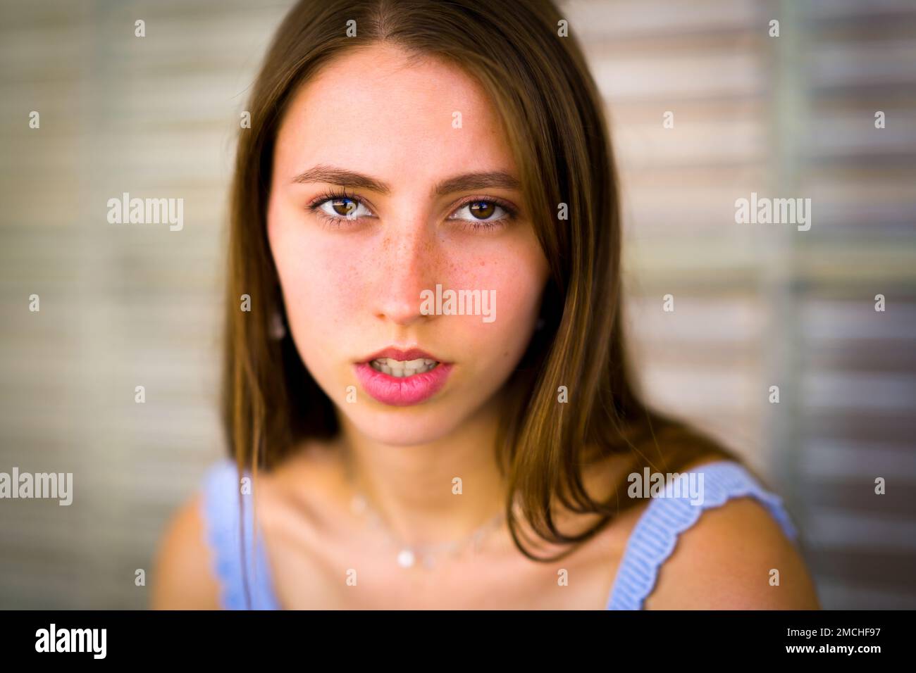 Nahaufnahme des Porträts von Teenage Girl, das sich gegen ein Art déco-Fenster aus Glas lehnt Stockfoto