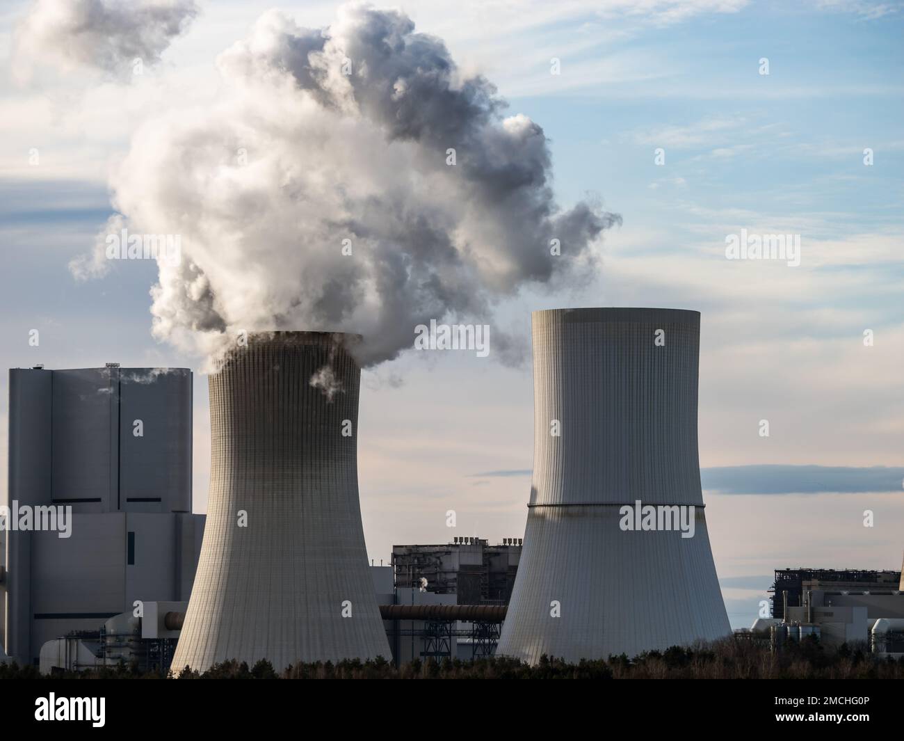 Rauch eines Braunkohlekraftwerks verunreinigt die Luft. Feinstaub und Treibhausgase wurden ausgestoßen. Nahaufnahme der Kühlturmgebäude. Stockfoto