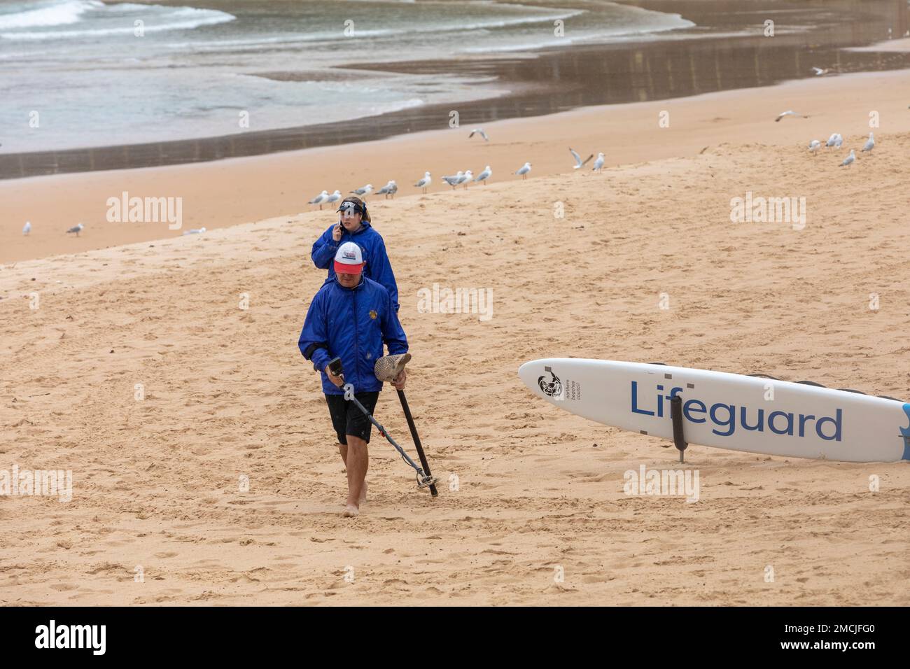 Metalldetektor, Paar mit Metalldetektor, Suche nach verlorenen Gegenständen oder Schätzen in Manly Beach, Sydney, Australien Stockfoto