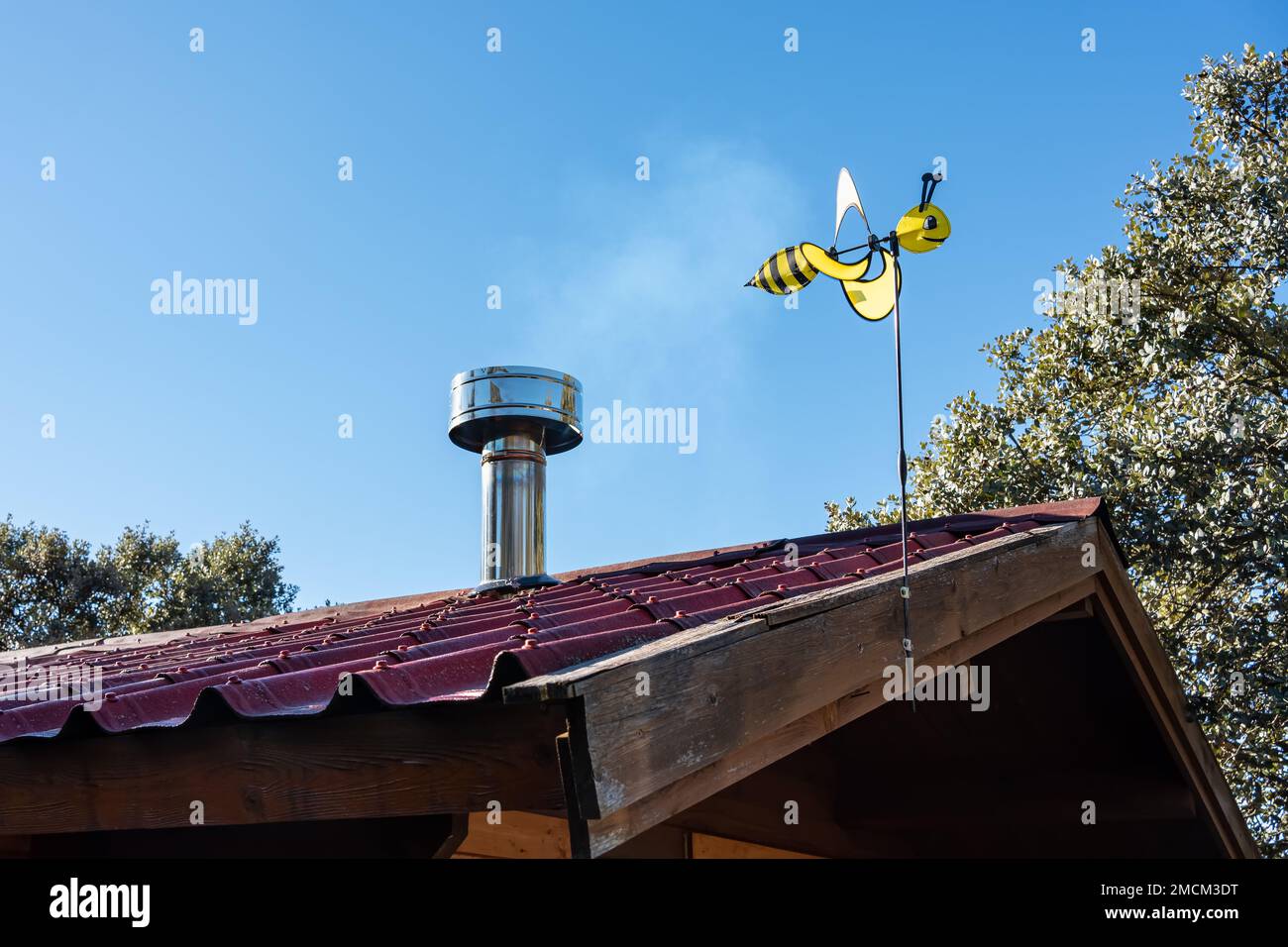 Eine Wespenform, die sich mit dem Wind auf dem Dach eines Holzhauses bewegt. Stockfoto