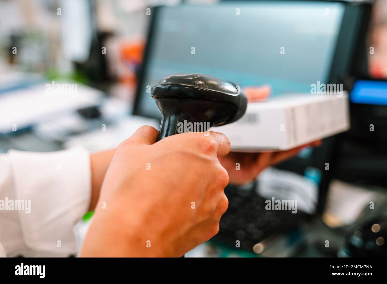 Der Apotheker verwendet einen Strichcodeleser, um ein Medikament zu identifizieren und zu verkaufen Stockfoto