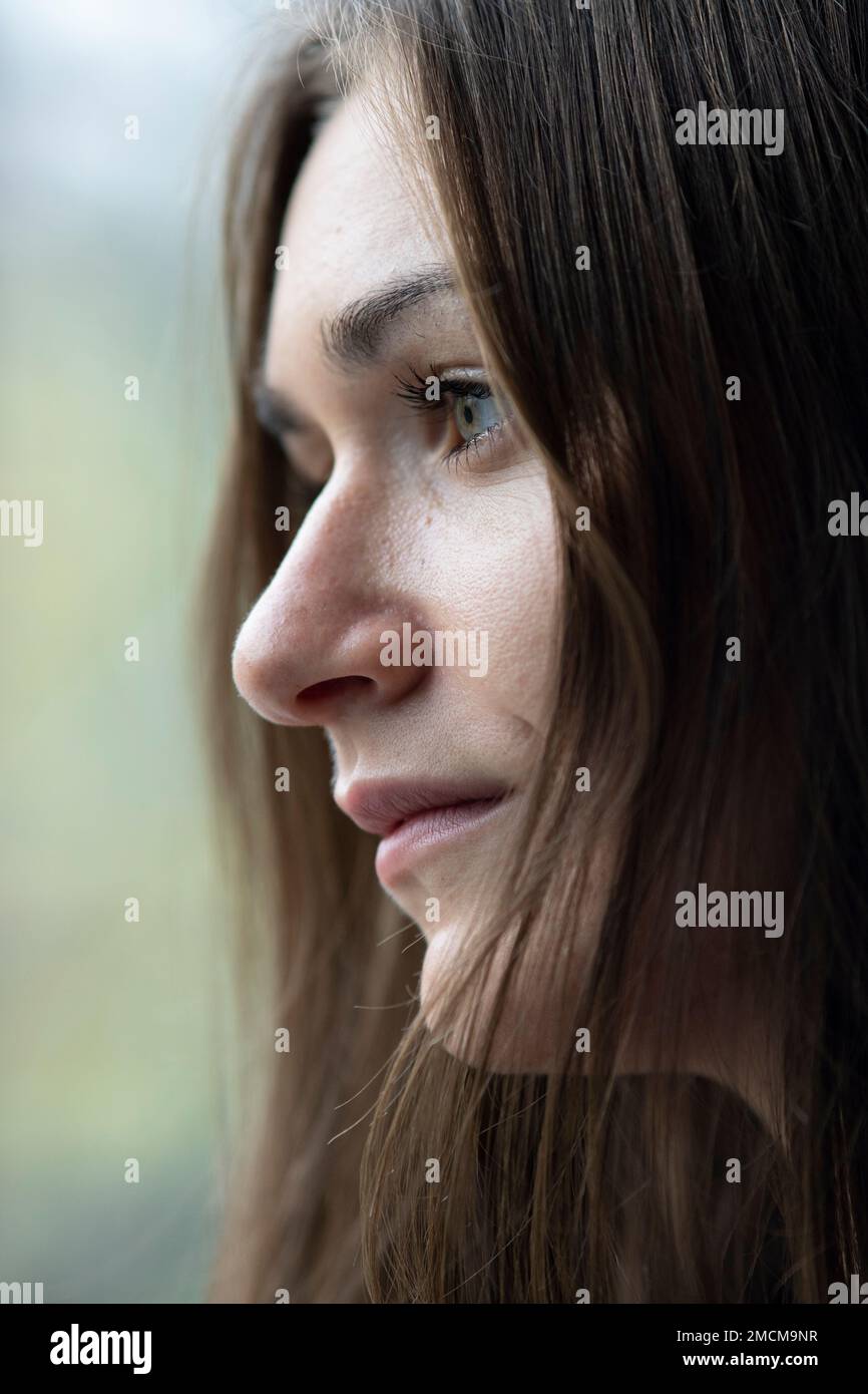Traurige Frau, Blick aus dem Fenster Stockfoto