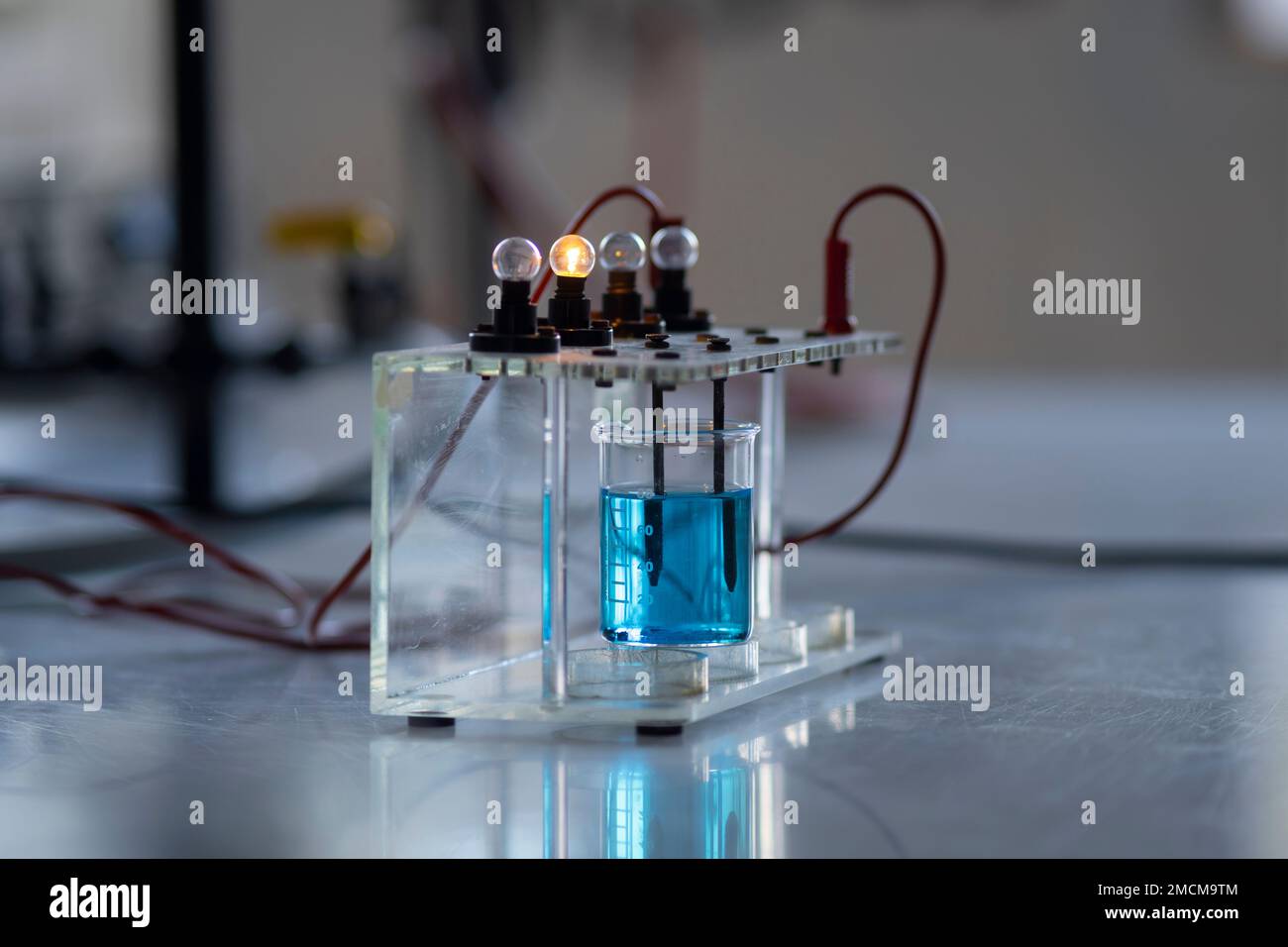 Elektrolytlösung schaltet eine Glühlampe ein. Experiment im Chemielabor Stockfoto