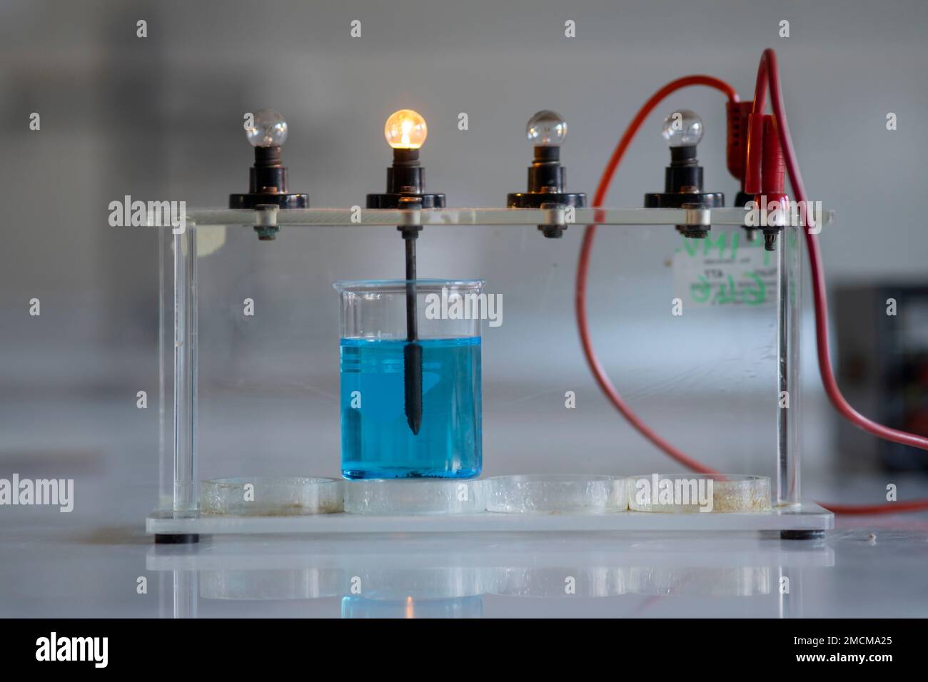 Elektrolytlösung schaltet eine Glühlampe ein. Experiment im Chemielabor Stockfoto