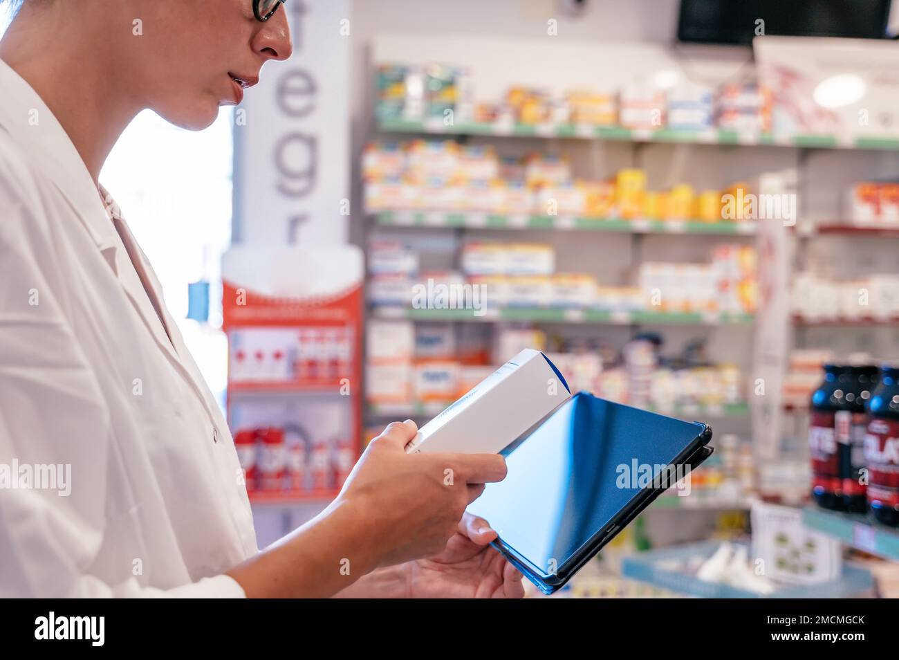 Eine Apothekerin prüft die Arzneimittel auf der Tablette Stockfoto