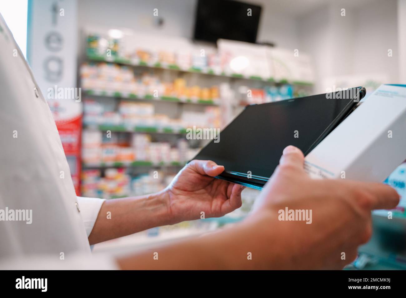 Eine Apothekerin prüft Informationen zu Arzneimitteln auf der Tablette Stockfoto