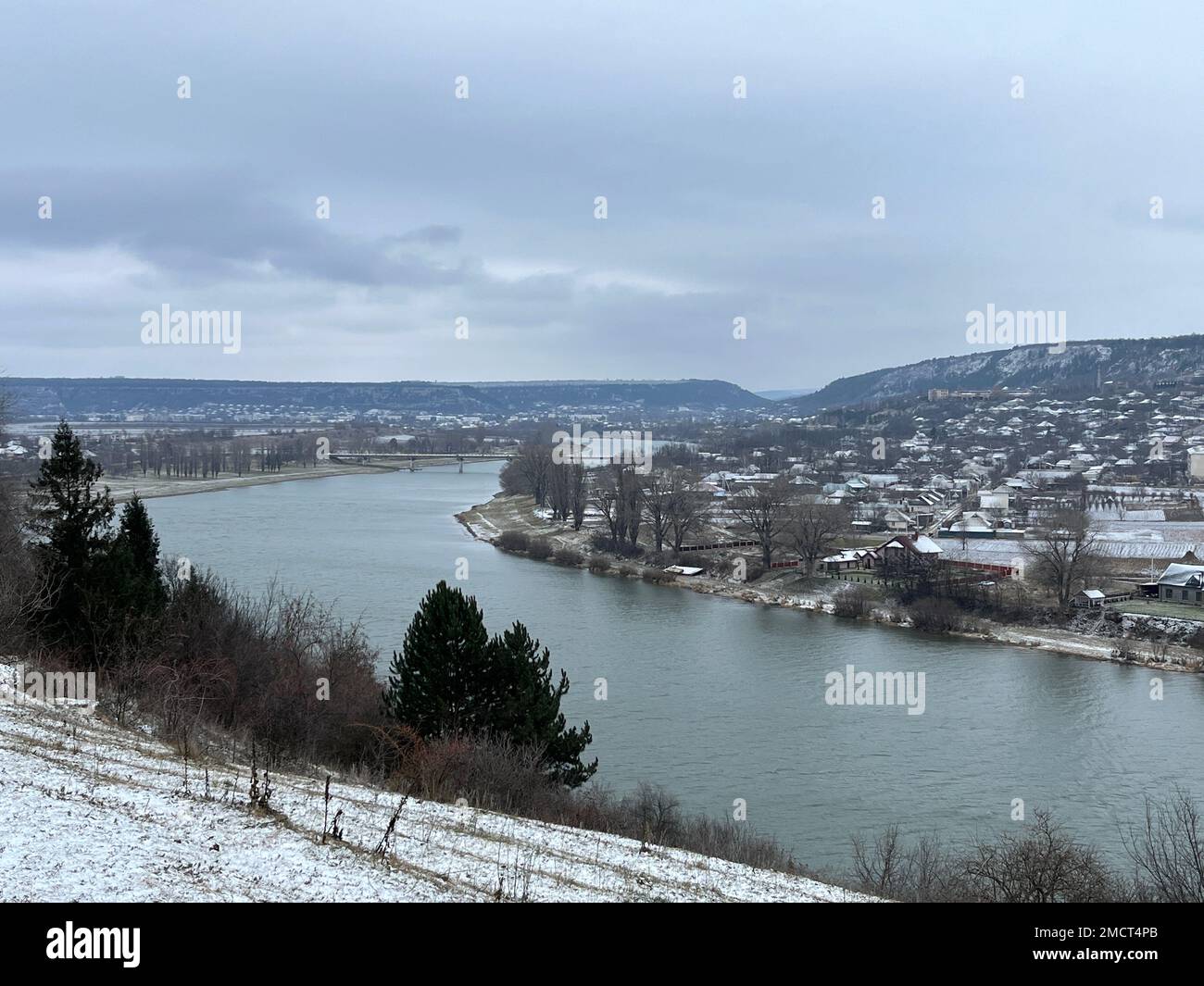 Eine wunderschöne Aussicht auf eine schneebedeckte Stadt in der Nähe des Flusses Stockfoto
