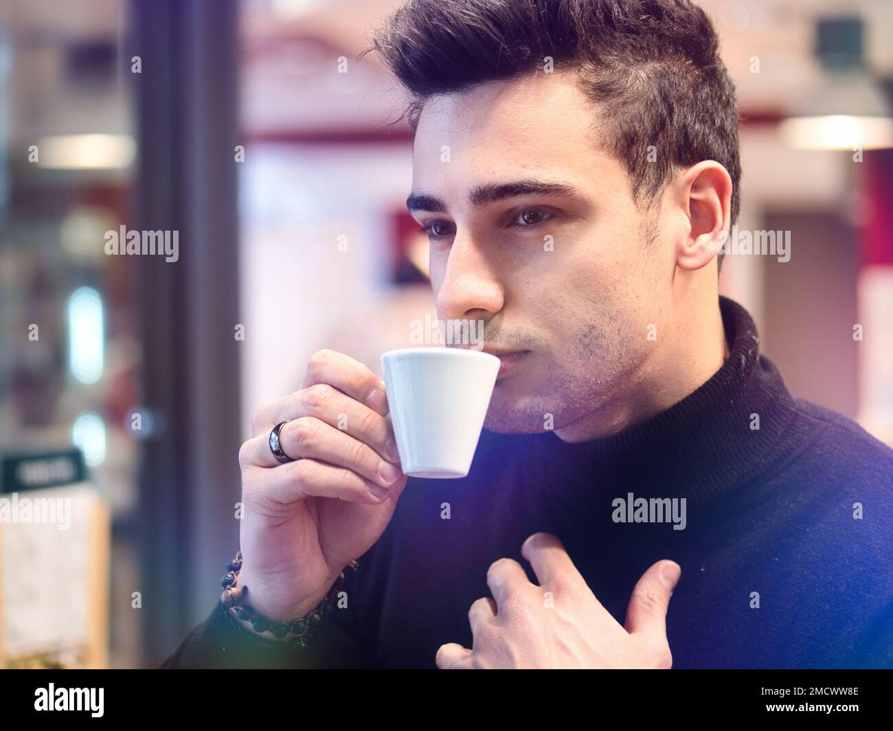 Mann trinkt Kaffee von außerhalb des Barfensters Stockfoto