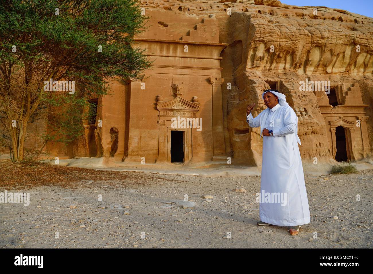 Rawi, Geschichtenerzähler, vor den nabatäischen Gräbern am Felsen Qasr Al-Bint, Hegra oder Madain Salih, Alula Region, Medina Provinz, Saudi-Arabien Stockfoto