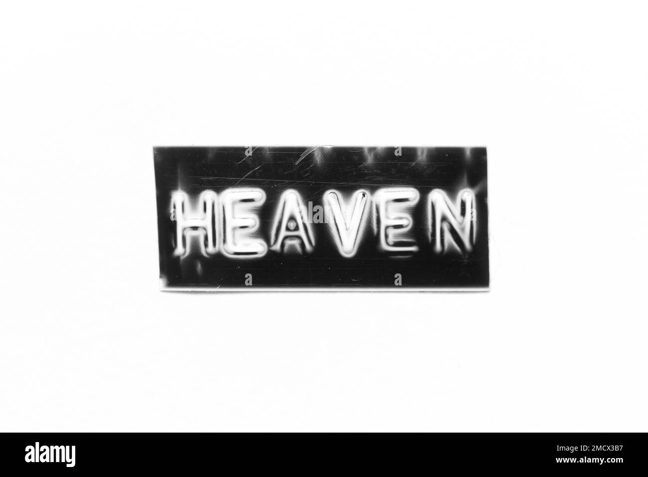 Schwarzes Banner mit geprägtem Buchstaben und Wort „Heaven“ auf weißem Papierhintergrund Stockfoto