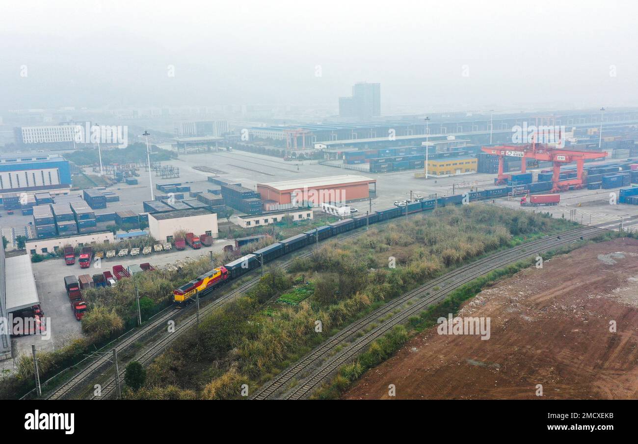 (230122) -- CHONGQING, 22. Januar 2023 (Xinhua) -- Dieses Luftfoto zeigt einen intermodalen Schienen-See-Güterzug, der Container mit Gütern transportiert, einschließlich Autos, Motorrädern, Motoren und Natriumcarbonat, Abfahrt vom Tuanjie Village Central Station im Südwesten Chinas Chongqing, 22. Januar 2023. Im Jahr des Hasen war es der erste Güterzug des neuen internationalen Land-Meer-Handelskorridors der Stadt. Die Waren im Zug werden zum Hafen von Qinzhou an der Südküste des Landes transportiert, von wo aus sie nach Indonesien, den Philippinen, Australien und einigen anderen Ländern transportiert werden Stockfoto