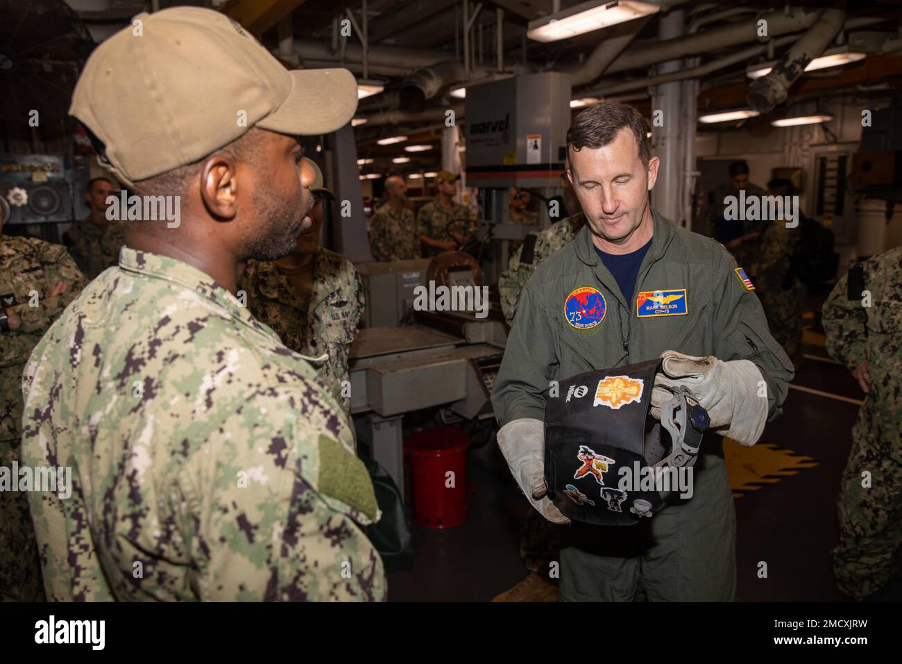 APRA HARBOR, Guam – Hull Technician Second Class Edson Toussaint, Left, dem U-Boot USS Emory S. Land (AS 39) zugewiesen, erläutert die Fähigkeiten der Schweiß- und Rohrwerkstatt an Rear ADM. Mark Melson, Right, Commander, Logistics Group Western Pacific/Commander, Task Force 73, während eines Besuchs im Juli 11. Land hat die Aufgabe, schnelle Wartungs- und Reparaturarbeiten auf mittlerer Ebene durchzuführen sowie Hotelservice und Logistikunterstützung für bereitgestellte geführte Raketen und Schnellangriff-U-Boote bereitzustellen, die in Zuständigkeitsbereiche der US-5.- und US-7.-Flotte eingesetzt werden. Stockfoto