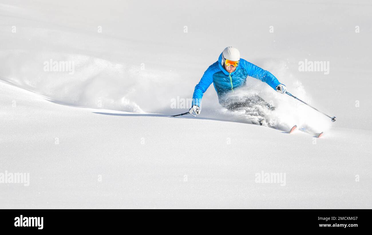 Skifahrer in Pulverform während einer Schnitzerei an einem Tag mit freier Fahrt Stockfoto