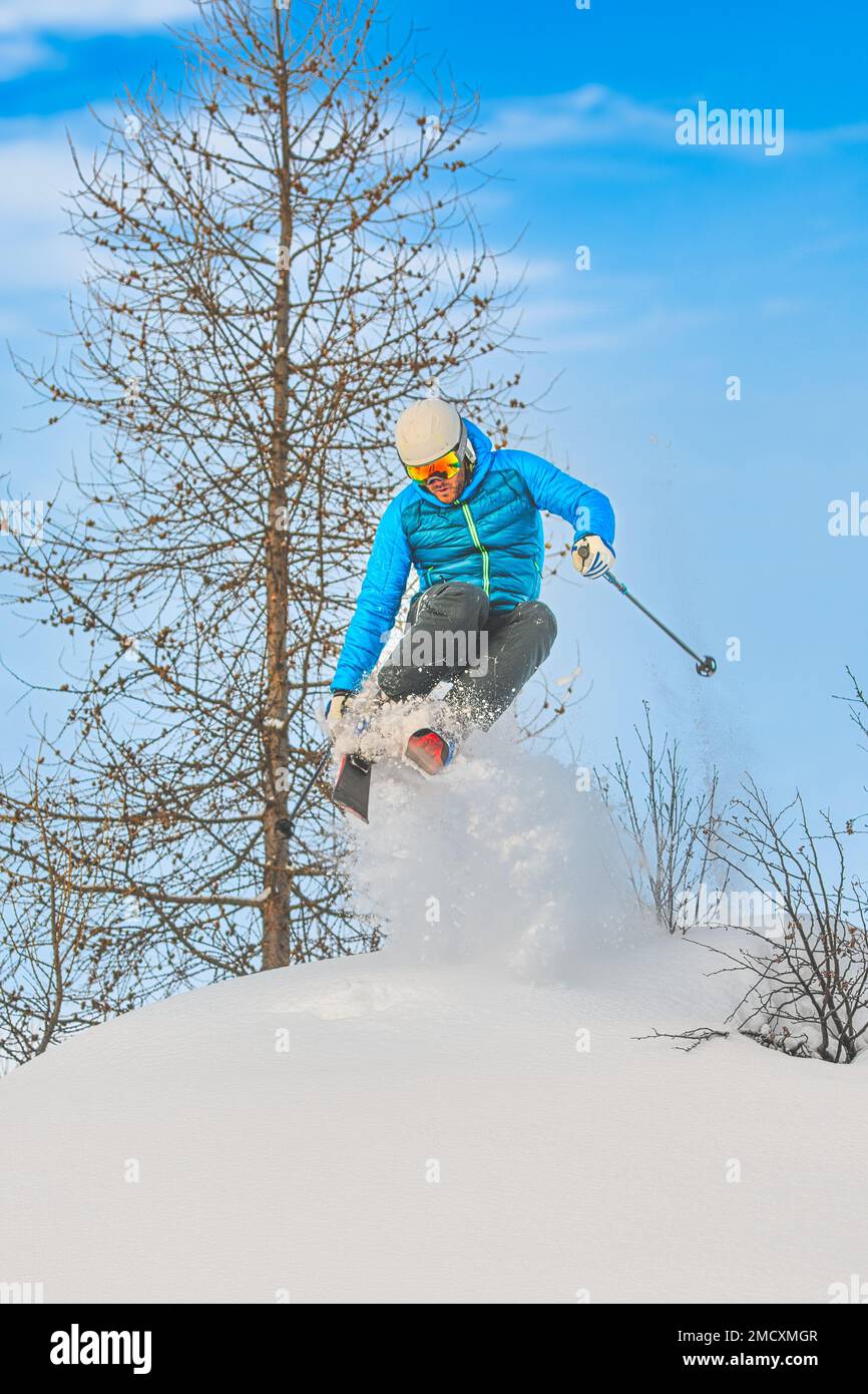 Skifahrer springen abseits der Piste in den tiefen Schnee Stockfoto