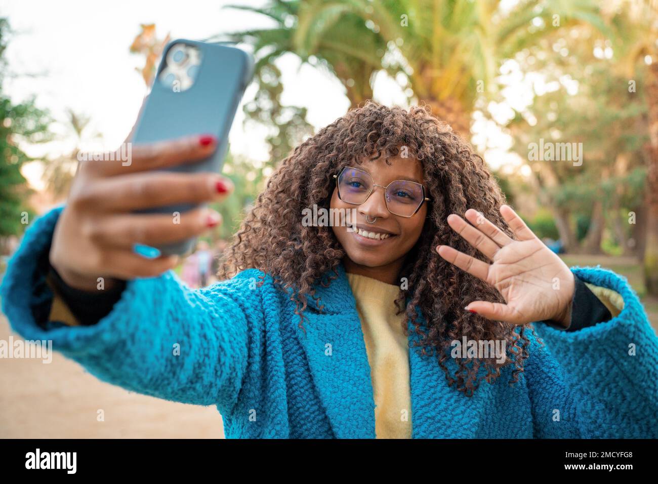 Attraktive schwarze Frau lächelt Selfie mit Smartphone. Positiv fröhliche afrikanische Frau. Stockfoto