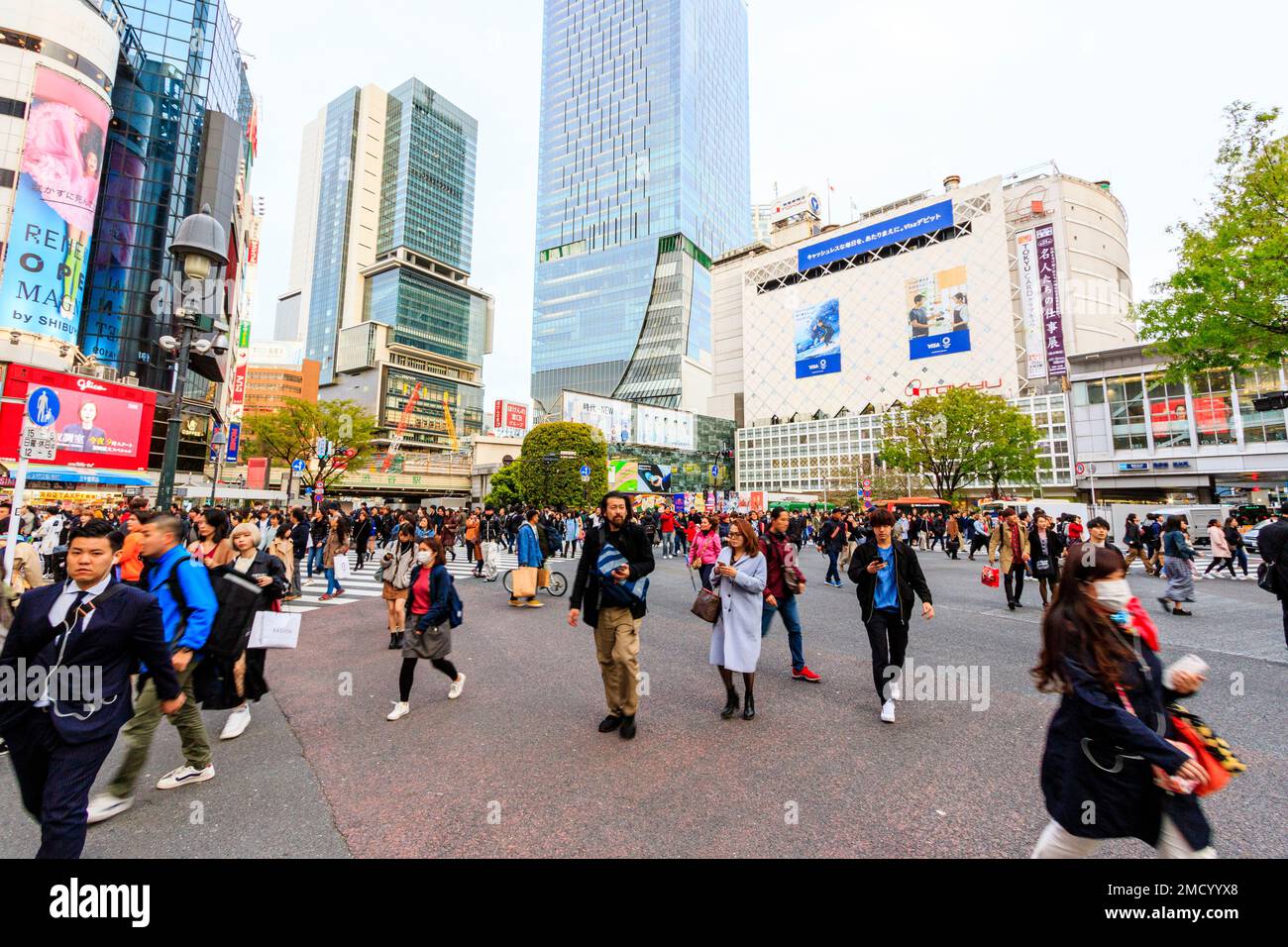 Tokio, Shibuya Wahrzeichen scramble Crossing. Massen von Menschen zu Fuß überqueren und direkt vor dem Bahnhof Shibuya auf Viewer. Straße. Stockfoto