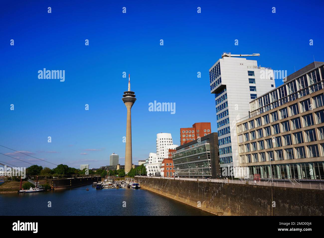 Medienhafen in Düsseldorf mit Düsseldorfs Wahrzeichen, dem Rheinturm, und modernen Gehry-Gebäuden von Frank O. Gehry. Stockfoto