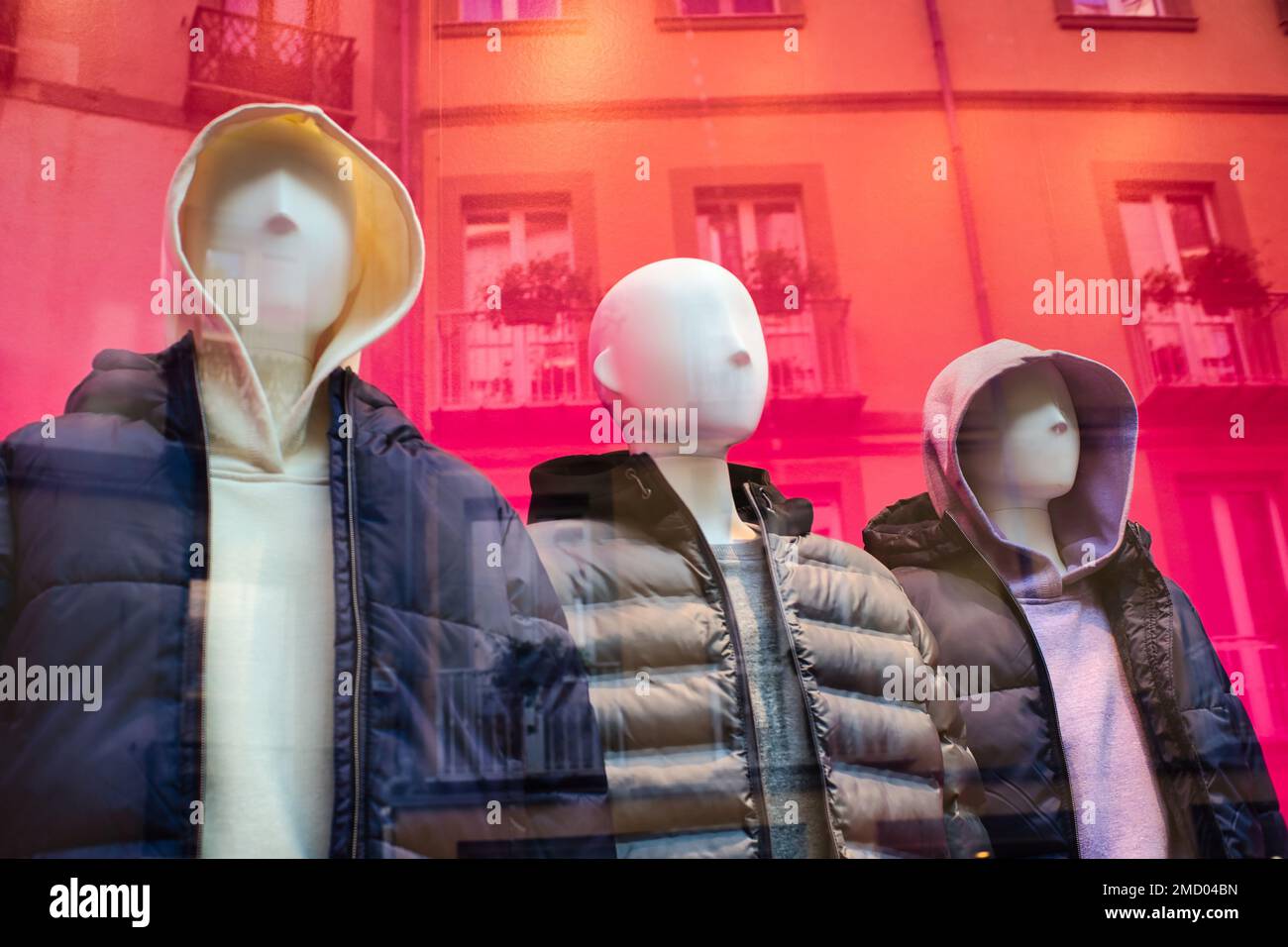 Eine Gruppe von drei Dummies in einem Modegeschäft mit einem Wohngebäude im Hintergrund Stockfoto