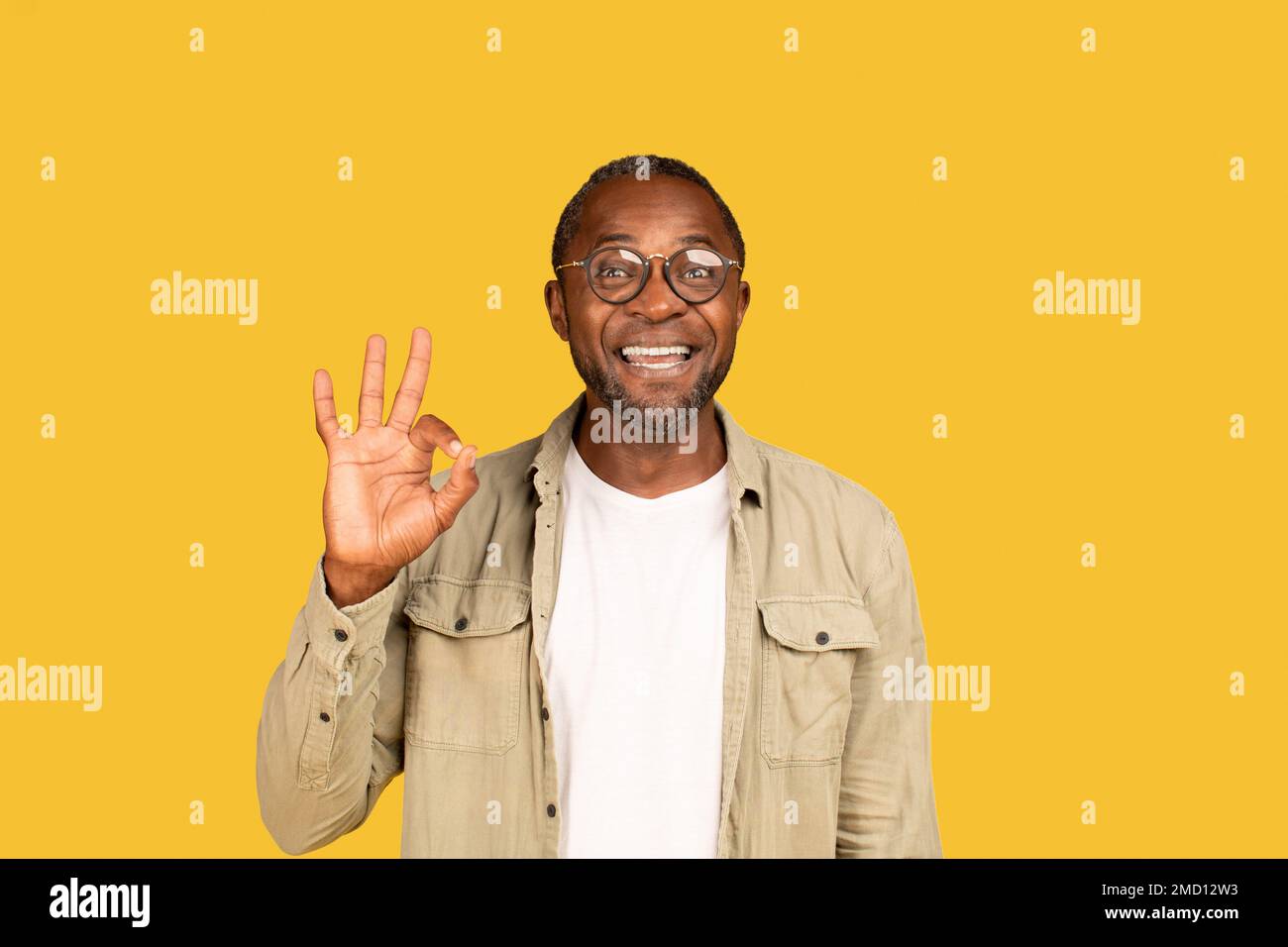 Glücklicher afroamerikanischer Mann mittleren Alters in Brille zeigt mit der Hand "OK" -Schild, schau in die Kamera Stockfoto