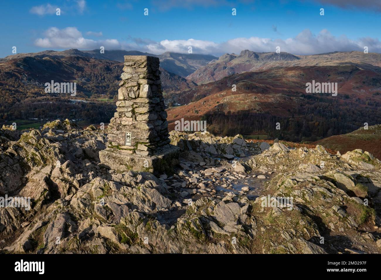 Der Trig Point auf Loughrigg fiel im Herbst von Great Langdale & The Langdale Pikes, Lake District National Park, Cumbria, England, UK, unterstützt Stockfoto