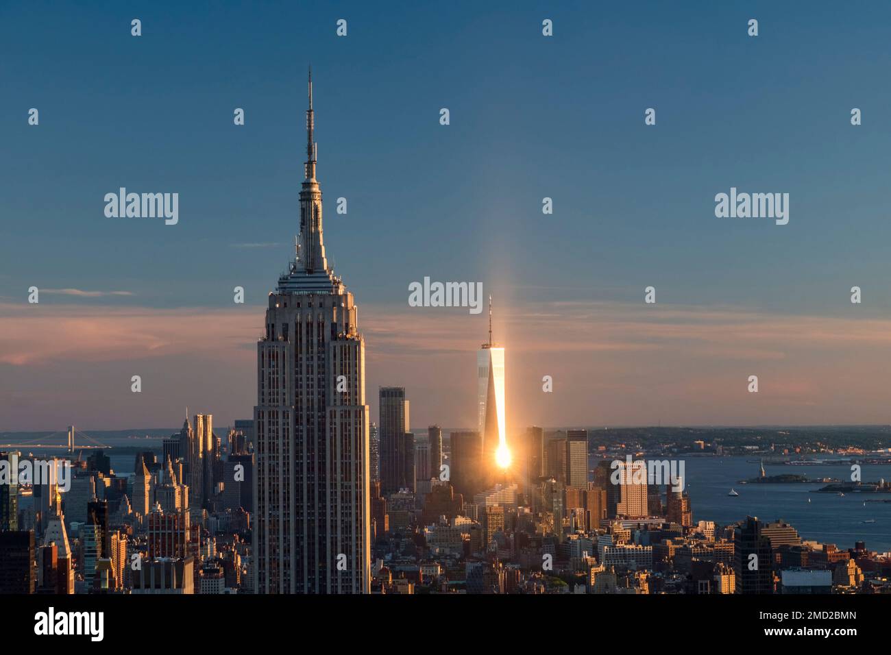 Das Sonnenlicht scheint vom One World Trade Center im Schatten des Empire State Building, New York, USA Stockfoto