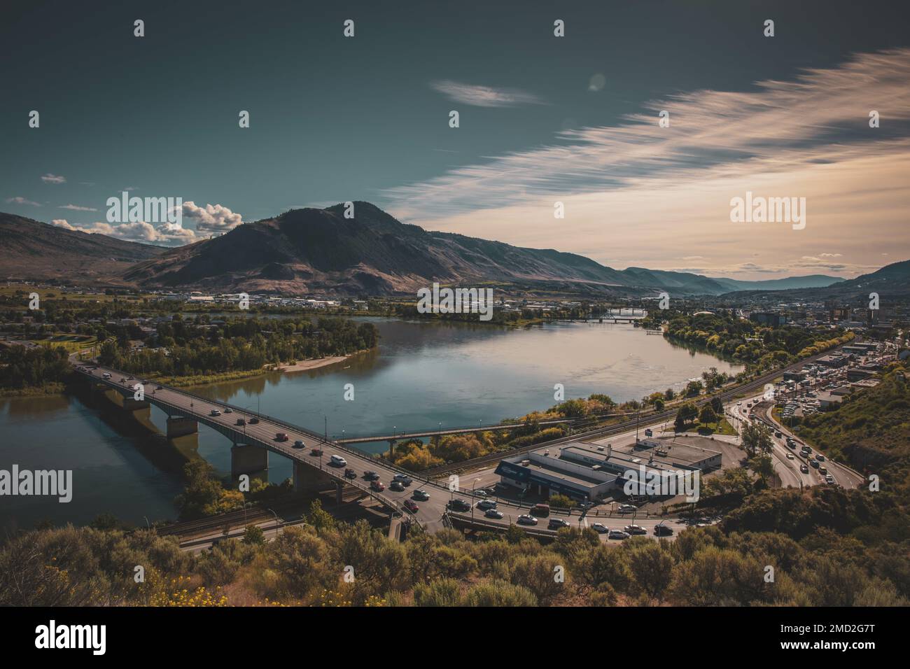 Kamloops, British Columbia, Kanada im Sommer von einem erhöhten Ort. Zeigt die Thompson River Bridge mit Verkehr, der den Fluss überquert. Stockfoto