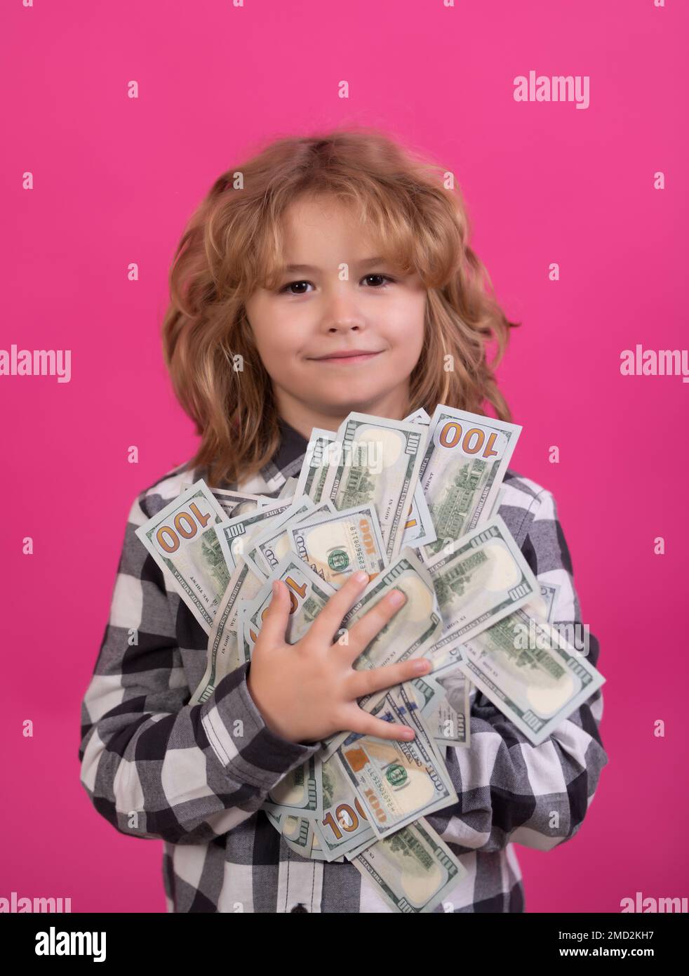 Der Junge hat viele hundert Dollar isoliert auf rosa rotem Hintergrund. Stockfoto