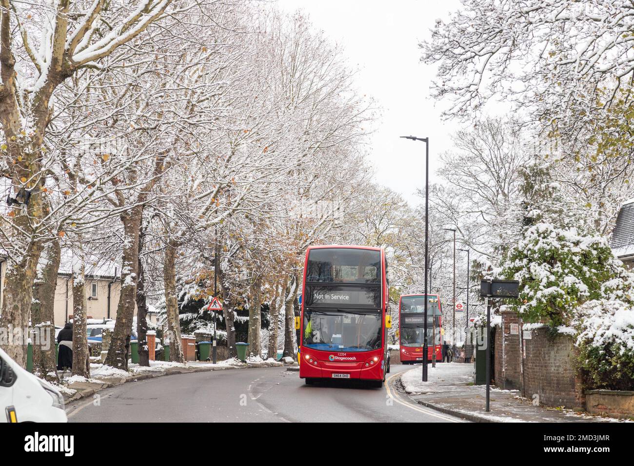 LONDON, Vereinigtes Königreich - 13. DEZEMBER 22: Öffentliche Doppeldeckerbusse auf Straßen während der Wintermonate, wenn es schneit. Stockfoto