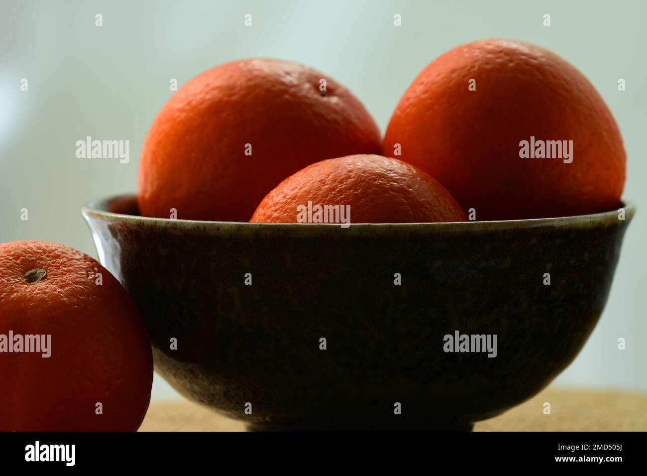 Nahaufnahme frischer und saftiger heller orangefarbener Mandarinen auf dunklem Hintergrund; geringe Schärfentiefe Stockfoto