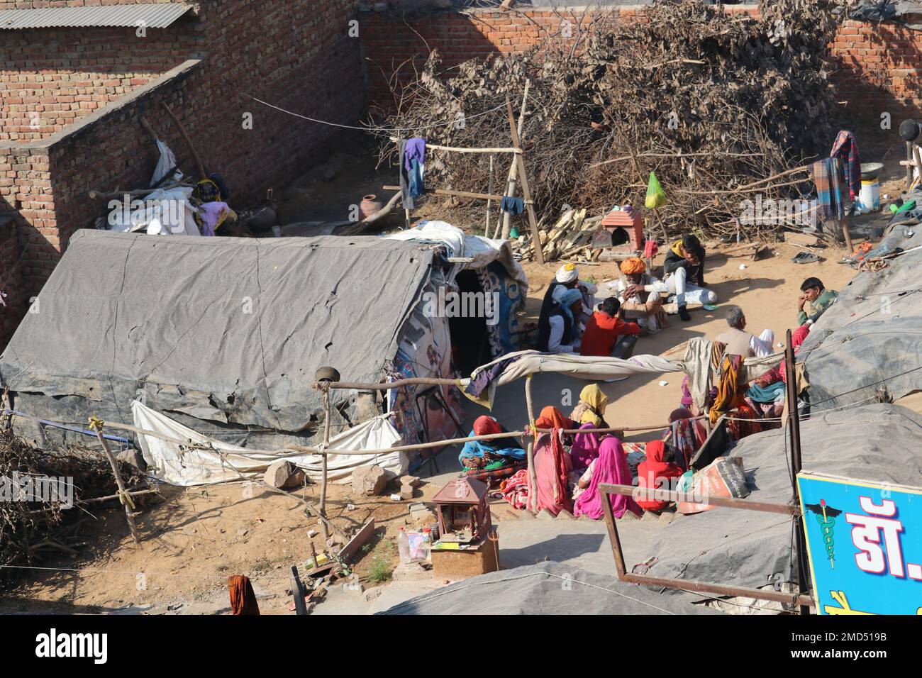 Haryana/Indien: Indianer, die kein eigenes Zuhause haben. Die Leute sonnen sich nach einer kalten Nacht im Sonnenlicht. Stockfoto