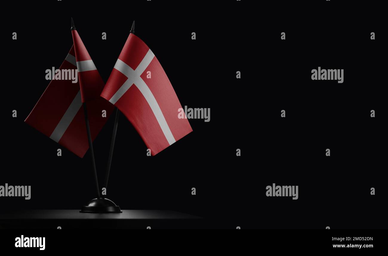 Kleine dänische Staatsflaggen auf schwarzem Hintergrund. Stockfoto