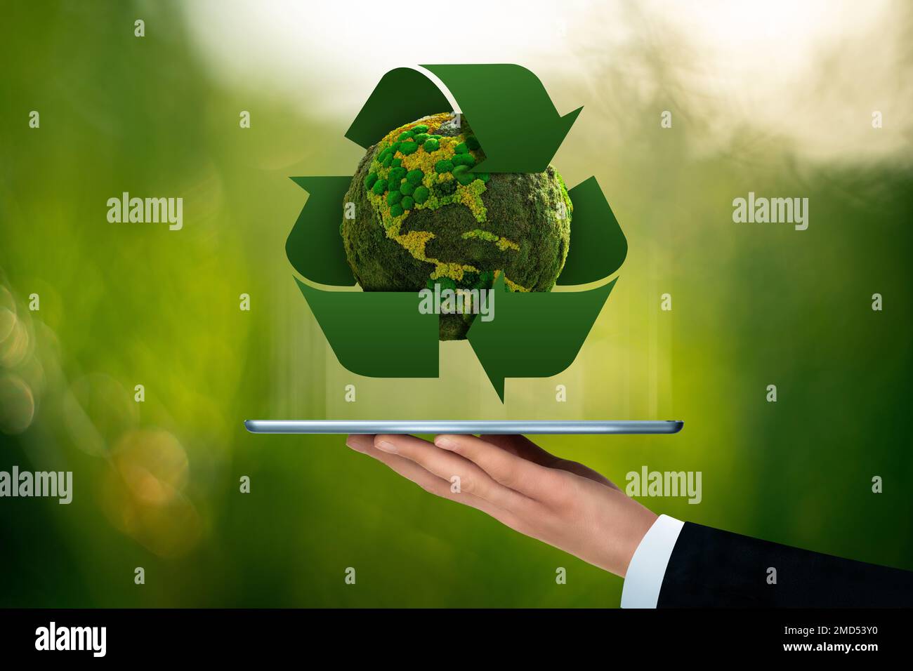 Ein Geschäftsmann hält ein digitales Tablet mit dem grünen Planeten Erde und dem Recycling-Symbol in der Hand. Konzept Stockfoto