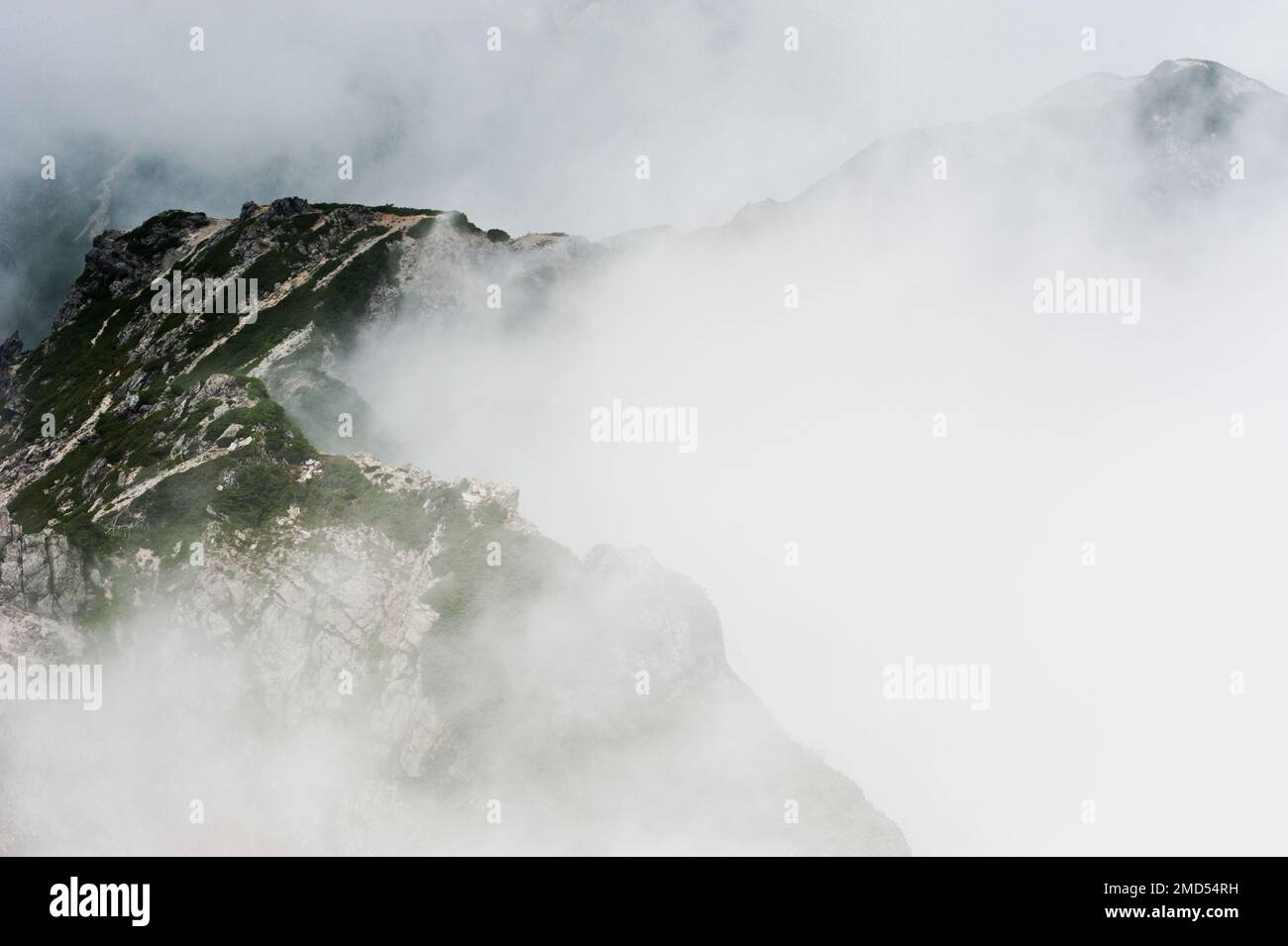 Die zerklüftete Landschaft der nordjapanischen Alpen zwischen dem Karamatsu und dem Goryu ist von Wolken umgeben. Stockfoto