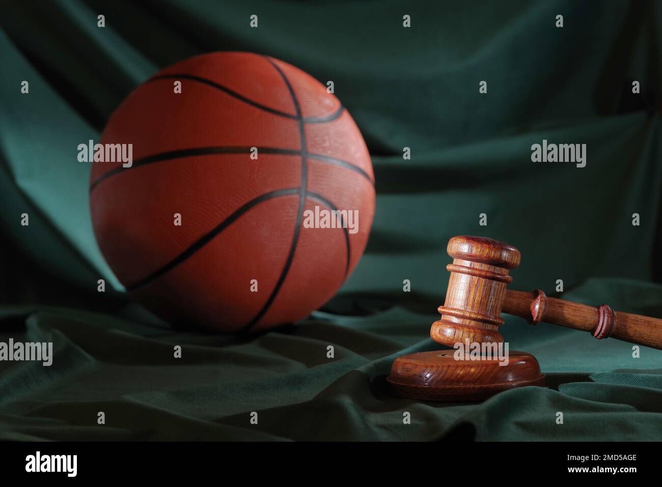 Sport und Gerechtigkeit. Hölzerner Hammer und Basketball Stockfoto