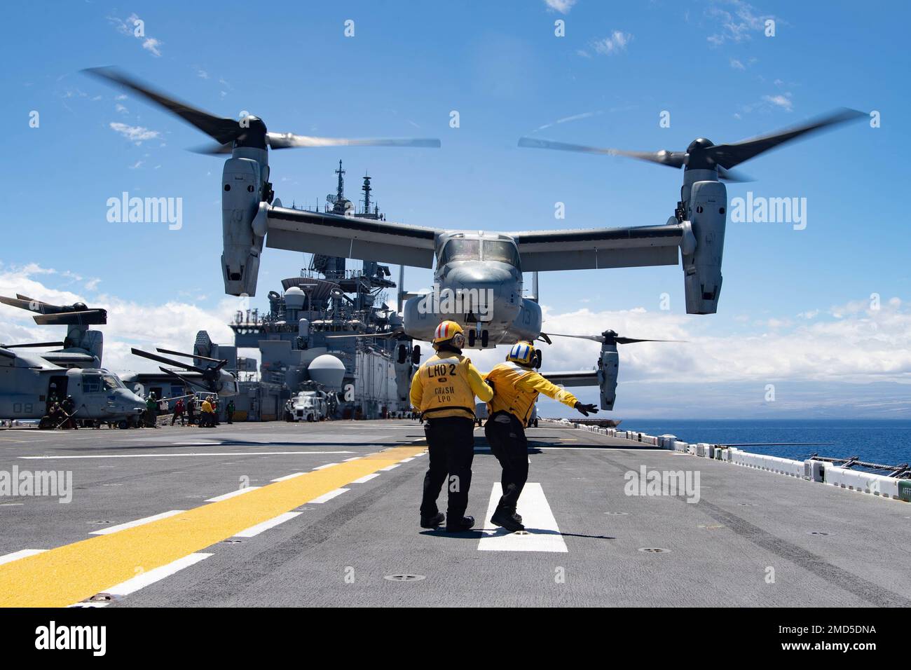 PACIFIC OCEAN (13. Juli 2022) Airman Shaion Plummer, aus New York City, rechts, unter Anleitung von Aviation Boatswain’s Mate (Handling) 1. Class Mark Usi, aus Spring Valley, Kalifornien, Signale an einen MV-22 Osprey, der an Marine Medium Tiltrotor Squadron (VMM) 363 angeschlossen ist, als er während des Rim of the Pacific (RIMPAC) 2022 vom Flugdeck des amphibischen Sturmschiffs USS Essex (LHD 2) der Wasp-Klasse abhebt. 26 Nationen, 38 Schiffe, vier U-Boote, mehr als 170 Flugzeuge und 25.000 Mitarbeiter nehmen vom 29. Juni bis zum 4. August an RIMPAC in und um die Hawaii-Inseln und den Süden Calis Teil Stockfoto