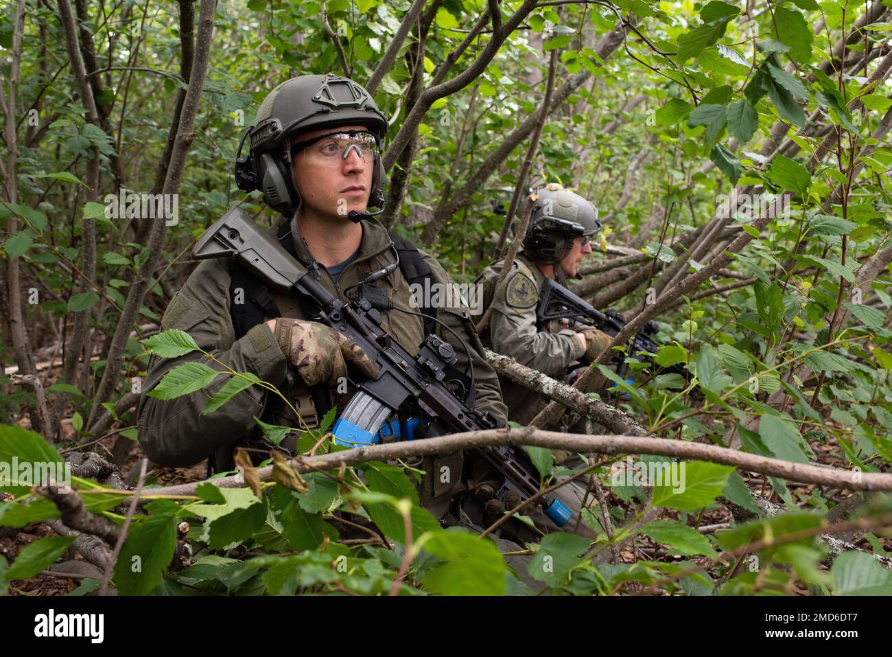 Offiziere des Spezialwaffenkommandos der Polizei von Anchorage (SWAT) halten während einer Ausbildungsübung für ländliche Einsätze auf der Gemeinsamen Basis Elmendorf-Richardson, Alaska, am 13. Juli 2022 Sicherheitskräfte. Die ausgedehnten und strengen Ausbildungsbereiche von JBER boten den idealen Rahmen für örtliche Einsatzteams der Strafverfolgungsbehörden, da sie ihre Fähigkeiten im ländlichen Bereich, Aufgabenplanung, Aufklärung, Sicherheitsverfahren für Hubschrauber, Landnavigation, Team-Bewegung und Patrouille. Stockfoto