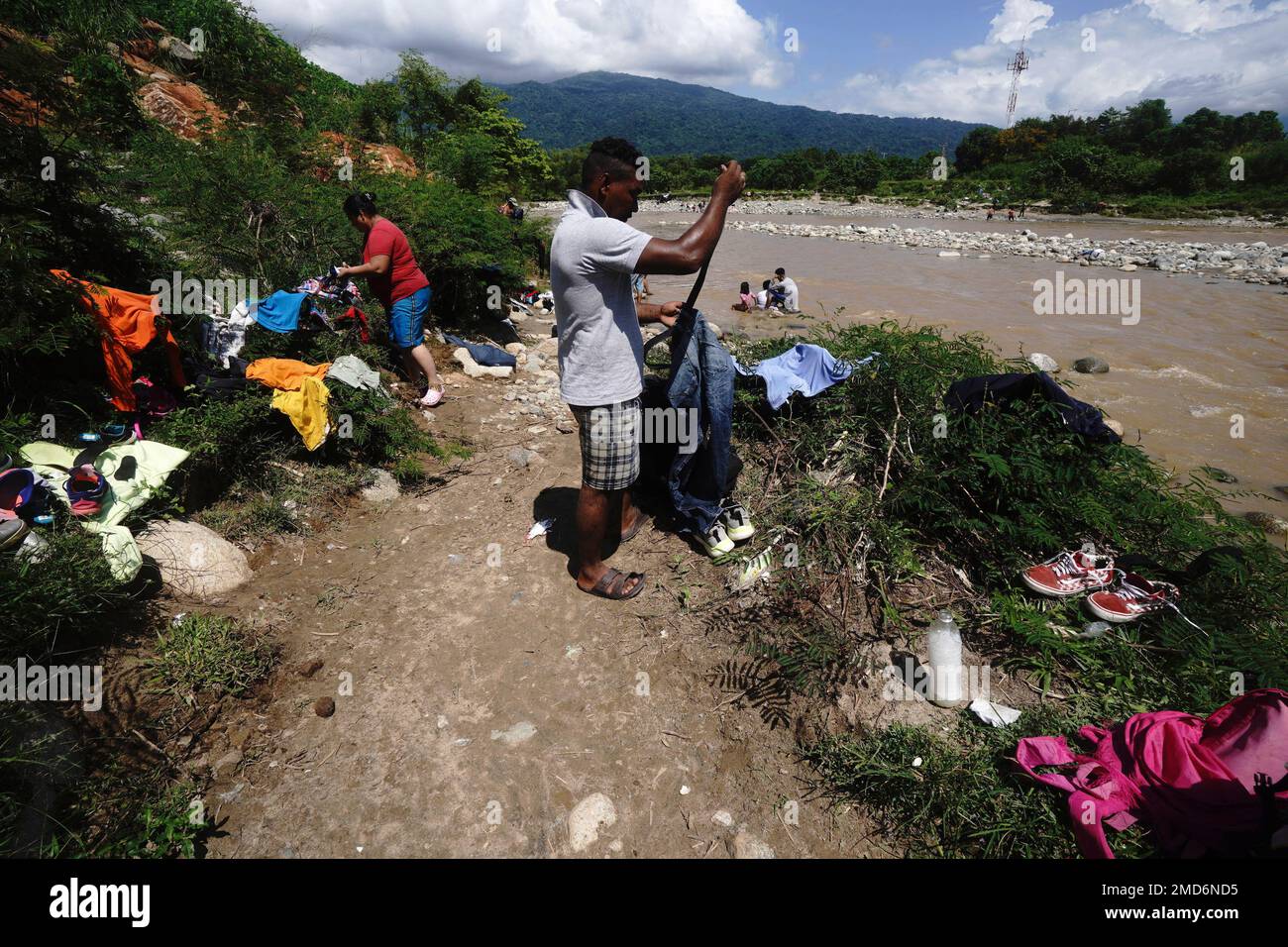 Migrants spread their clothes out to dry as others bathe in the Huixtla River, Chiapas state, Mexico, Tuesday, Oct. 26, 2021, as they take a day of rest before continuing their trek across southern Mexico to the U.S. border. (AP Photo / Marco Ugarte) Stockfoto