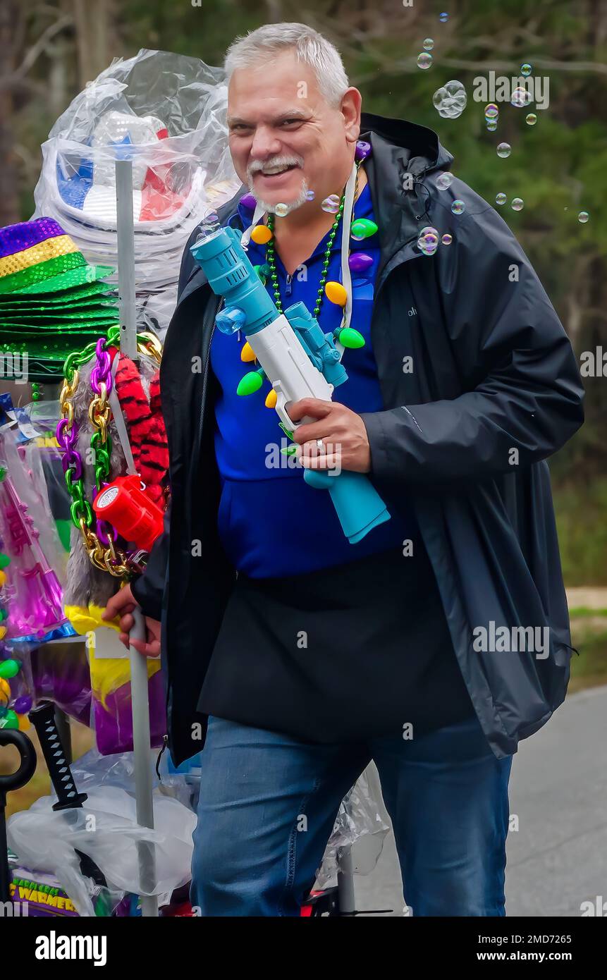 Bei der Mardi Gras-Parade auf Dauphin Island, Alabama, verkaufen Straßenverkäufer Blasengewehre und andere Schmuckstücke. Stockfoto