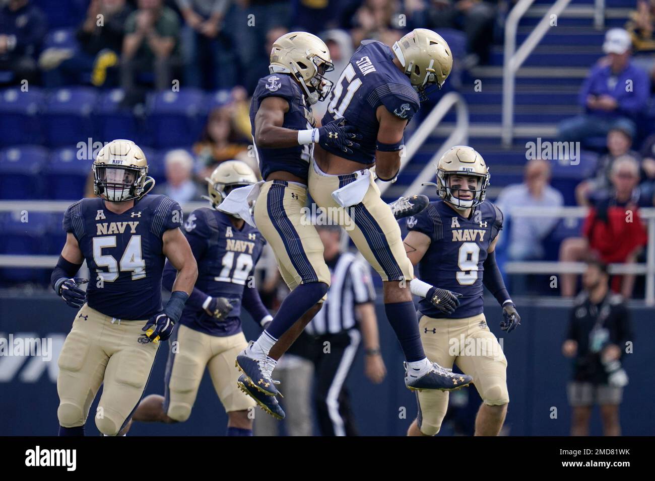 Navy cornerback Jamal Glenn, center left, celebrates with linebacker Nicholas Straw after Glenn intercepted a pass from Cincinnati quarterback Desmond Ridder, not visible, during the first half of an NCAA college football game, Saturday, Oct. 23, 2021, in Annapolis, Md. (AP Photo/Julio Cortez) Stockfoto