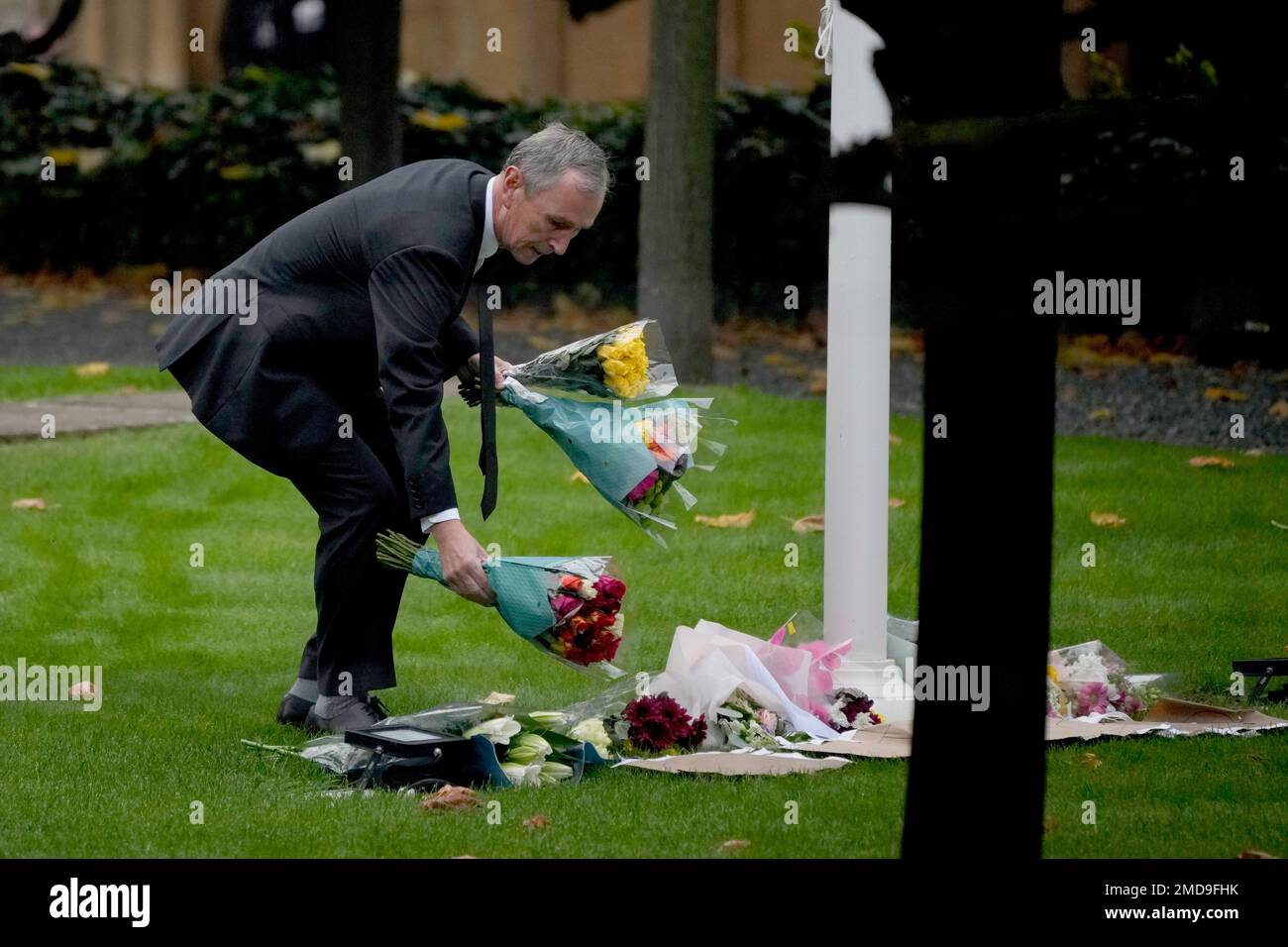 Conservative Party Member of Parliament Nigel Evans places flowers down for MP David Amess within the grounds of the Houses of Parliament in London, Monday, Oct. 18, 2021. British Prime Minister Boris Johnson will lead a special session of tributes in Parliament on Monday to the Conservative lawmaker stabbed to death as he met constituents, an attack that has fueled concern about politicians' safety and the level of vitriol directed at them. (AP Photo/Matt Dunham) Stockfoto