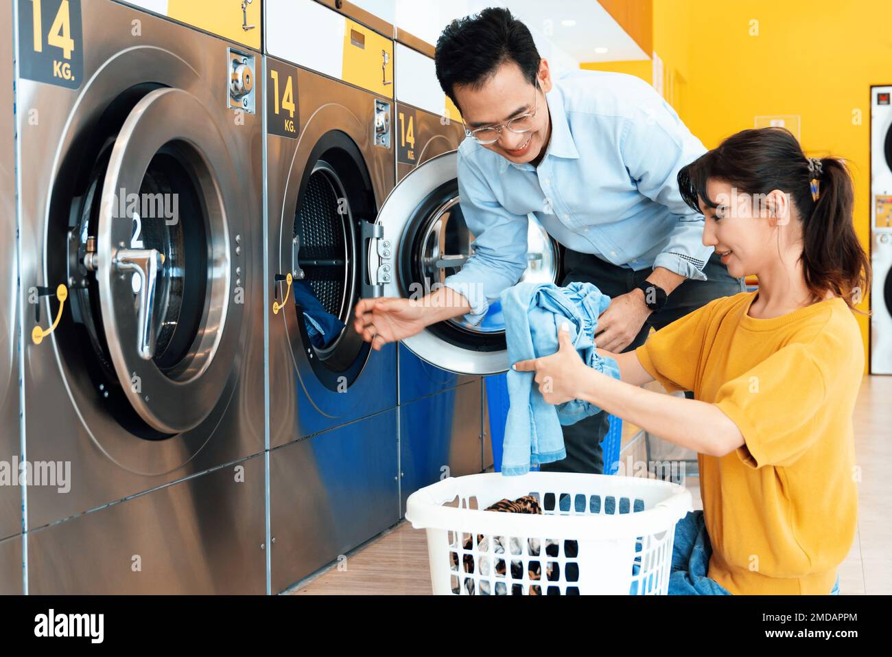 Asiatische Menschen benutzen im öffentlichen Raum eine münzbetriebene  Waschmaschine, um ihre Tücher zu waschen. Konzept einer kommerziellen  Self-Service-Wäscherei und Stockfotografie - Alamy