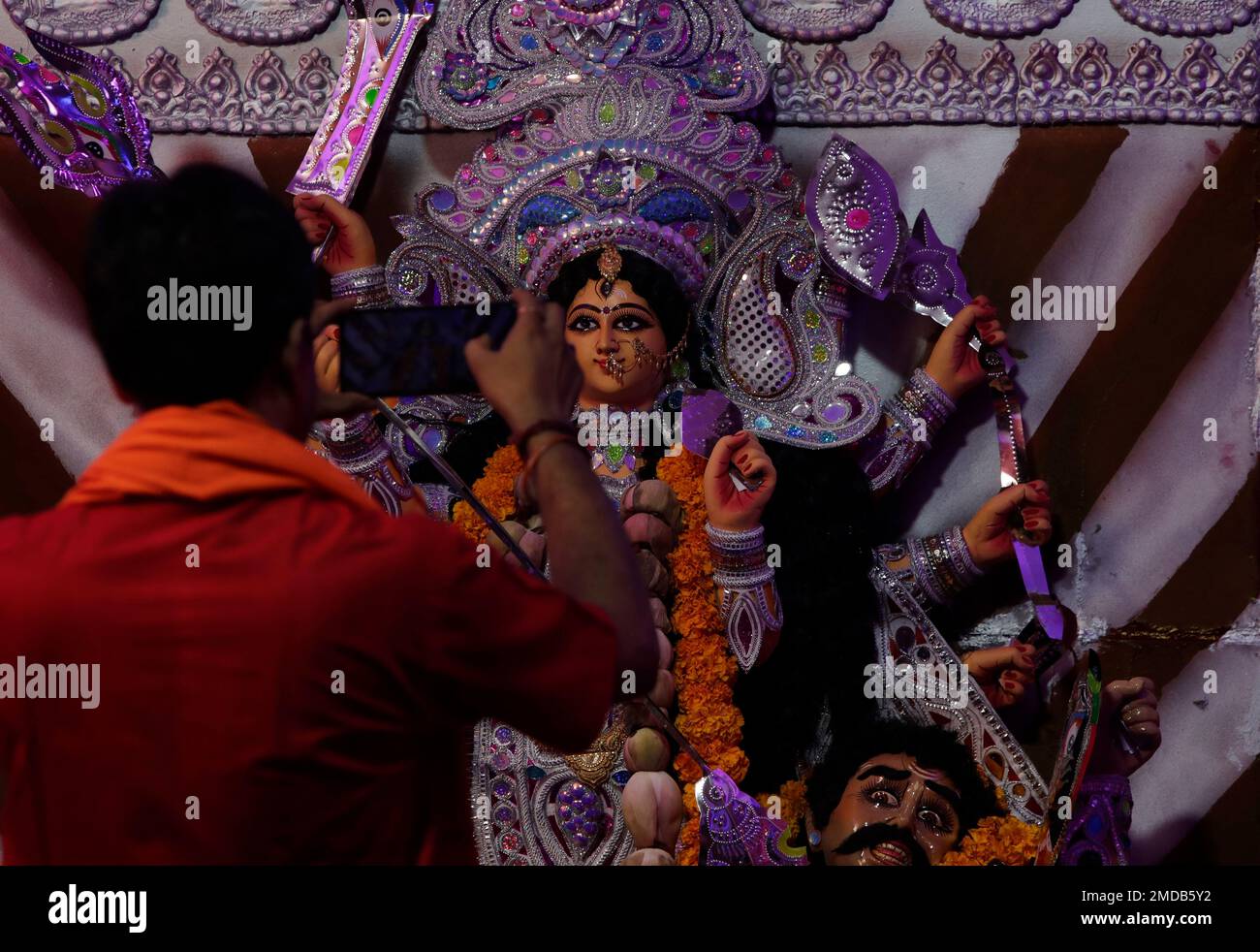 A Hindu priest takes photograph of an idol of goddess Durga during Durga Puja festival in Mumbai, India, Monday, Oct. 11, 2021. (AP Photo/Rajanish Kakade) Stockfoto