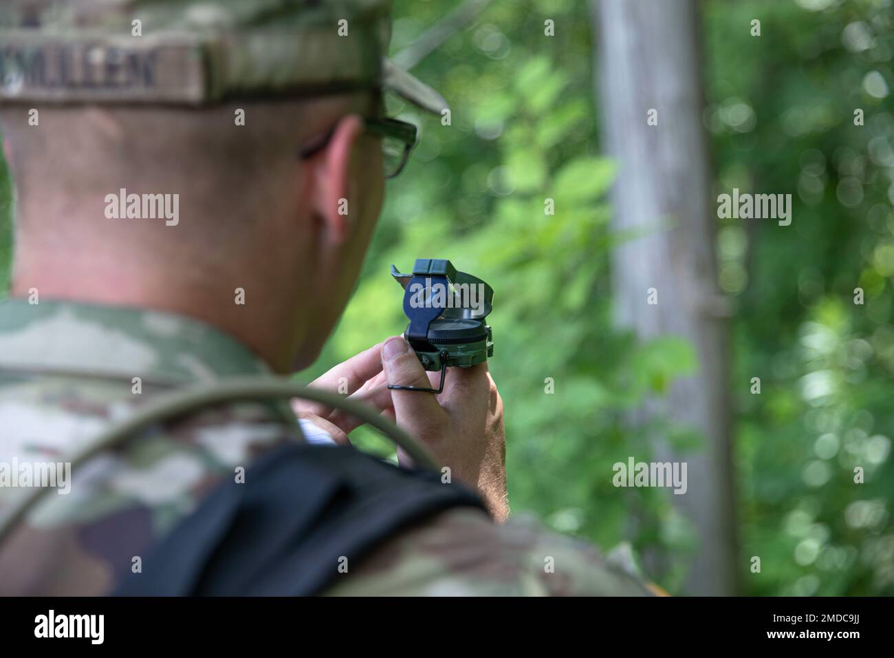 SPC. Tannor McMullen, der 233. Militärpolizei-Kompanie zugeteilt, nutzt seinen Kompass, um den nächsten Kontrollpunkt während des Gettysburg Landnavigation Kurses in Camp Ripley, Minnesota, 15. Juli 2022 zu finden. McMullen war mit Team vier unterwegs und beendete den Kurs als zweites insgesamt. Stockfoto