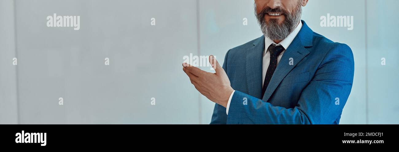 Porträt eines lächelnden erwachsenen Mannes, der auf weißem Hintergrund steht Stockfoto