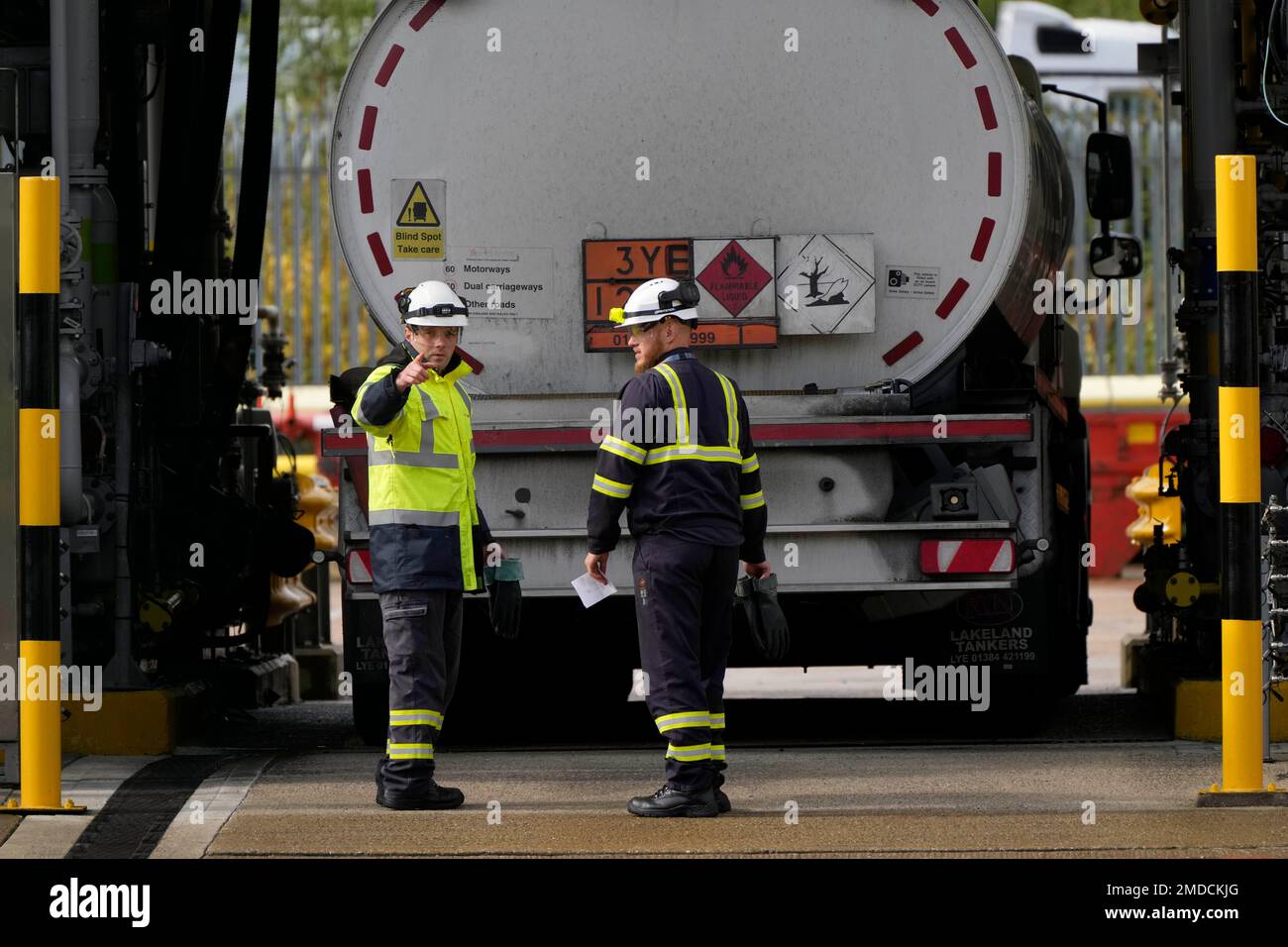 Workers prepare a fuel tanker at Buncefield Oil Depot near Hemel Hempstead, England, Tuesday, Oct. 5, 2021. British military personnel have begun delivering fuel to gas stations after a shortage of truck drivers disrupted supplies for more than a week. The crisis has led to long lines at the pumps as anxious drivers scrambled to fill their tanks. (AP Photo/Frank Augstein) Stockfoto