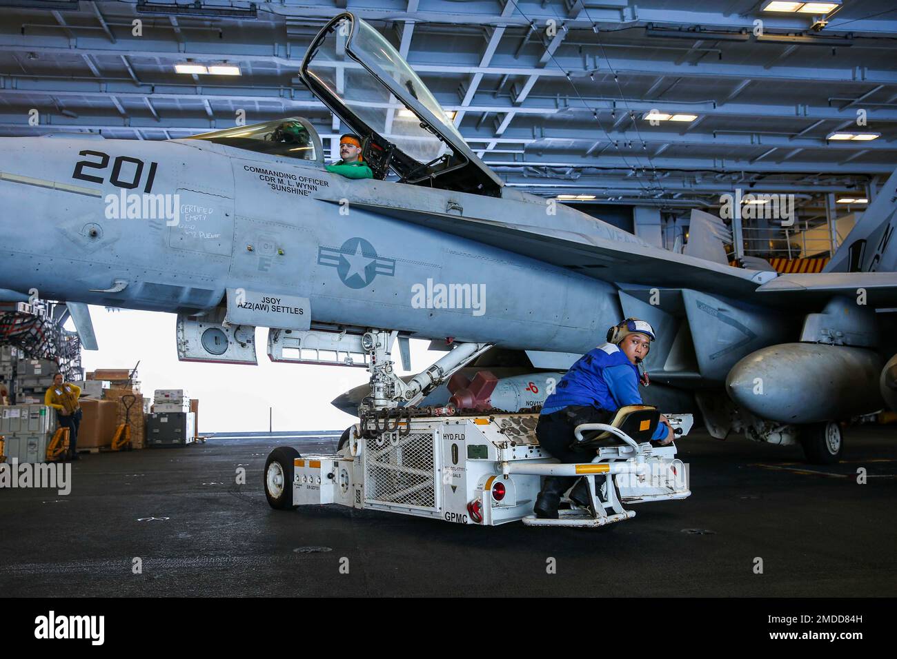 220716-N-VI910-1028 PACIFIC OCEAN (16. Juli 2022) Aviation Boatswain’s Mate (Handling) 3. Class Koji Iwasaki, aus Los Angeles, transportiert einen F/A-18E Super Hornet, der den „Tophatters“ des Strike Fighter Squadron (VFA) 14 zugeteilt ist, mit einem Spürhund in der Hangarbucht an Bord des Flugzeugträgers der Klasse Nimitz Abraham (CVS 72) Lincoln. Abraham Lincoln Carrier Strike Group führt Routineeinsätze in der US-3.-Flotte durch. Stockfoto