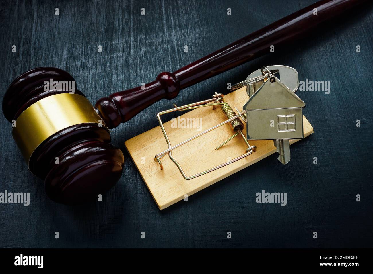 Eine Falle und ein Hausschlüssel neben dem Hammer. Das Konzept des Immobilienmietshandels. Stockfoto
