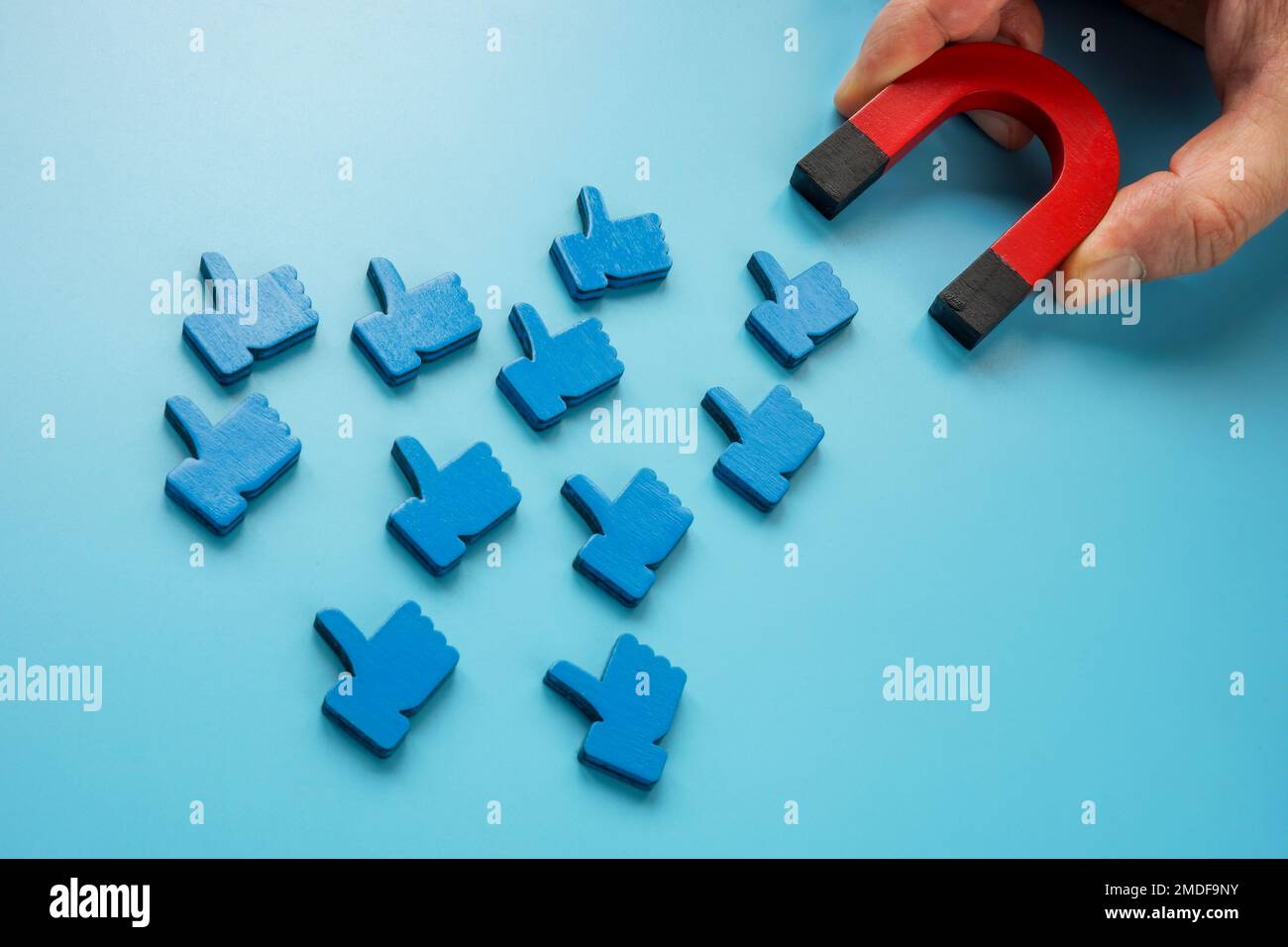 Eine Hand mit einem Magneten zieht soziale Medien wie Symbole an. Stockfoto