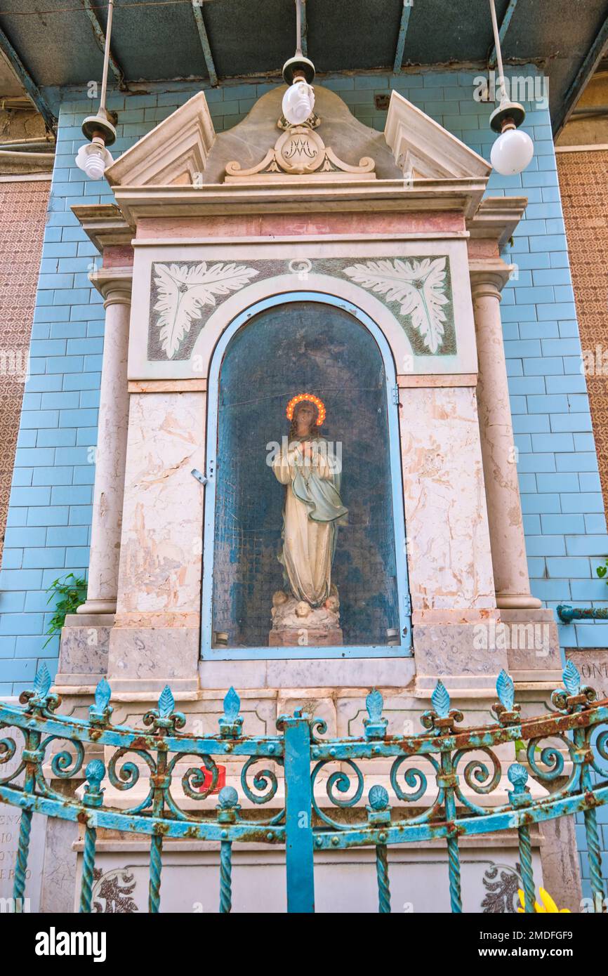 Einer der vielen kleinen, hausgemachten katholischen, christlichen Mauern, Straßenschreine, die man in jeder Nachbarschaft findet. Dieser Schrein ist aus blauen Fliesen mit einer Statue, Ikone Stockfoto