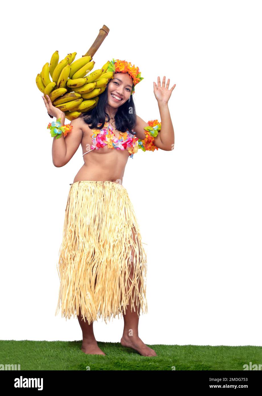 Hawaii Hula Dancer trägt einen Haufen grüner Bananen, isoliert auf weißem Hintergrund. Stockfoto